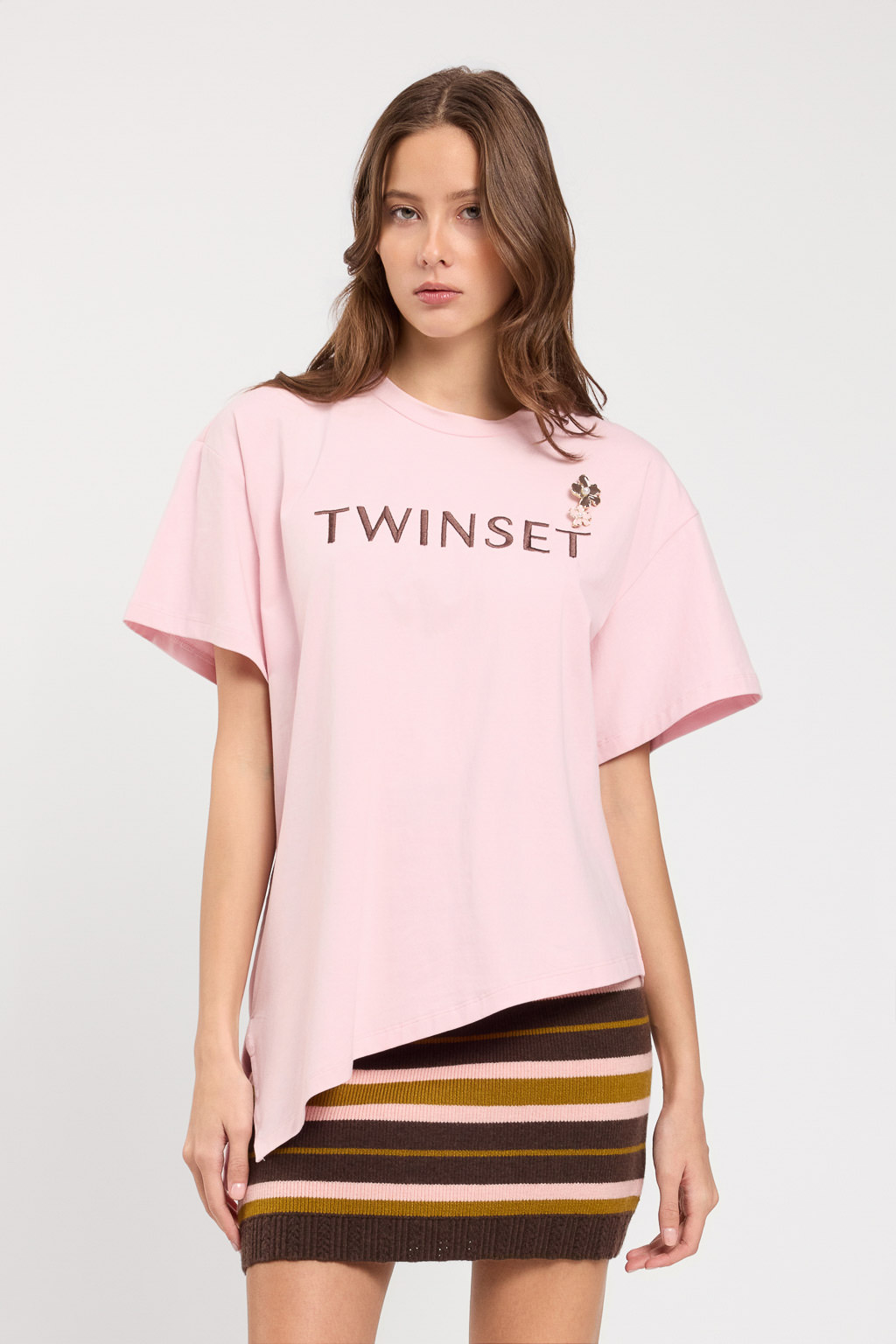 T-shirt da donna marchio TWINSET colore rosa powder rose con orlo asimmetrico a punta, logo ricamato e spilla a fiore removibile su Origami Store